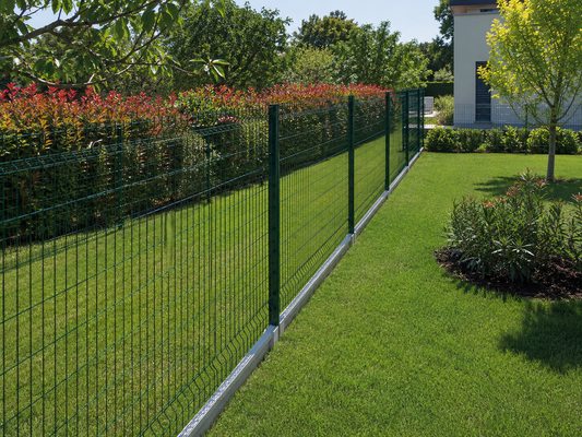 Dividere il giardino con rete metallica verde e paletti