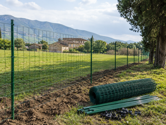 Recinzione campo con kit rete e paletti in fase di installazione